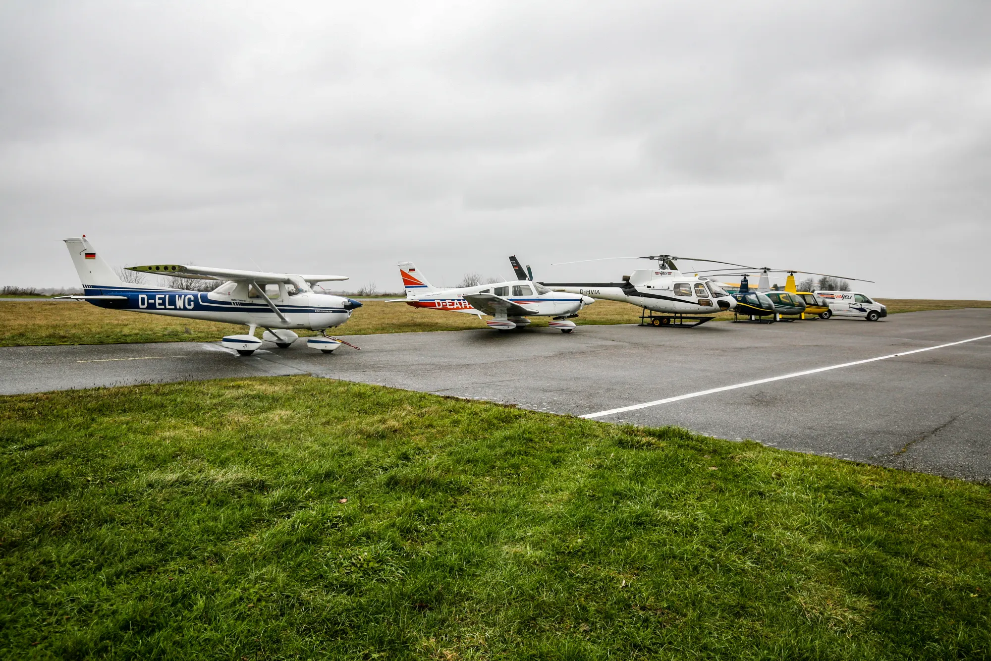 Flugzeuge und Hubschrauber nebeneinander auf dem Vorfeld