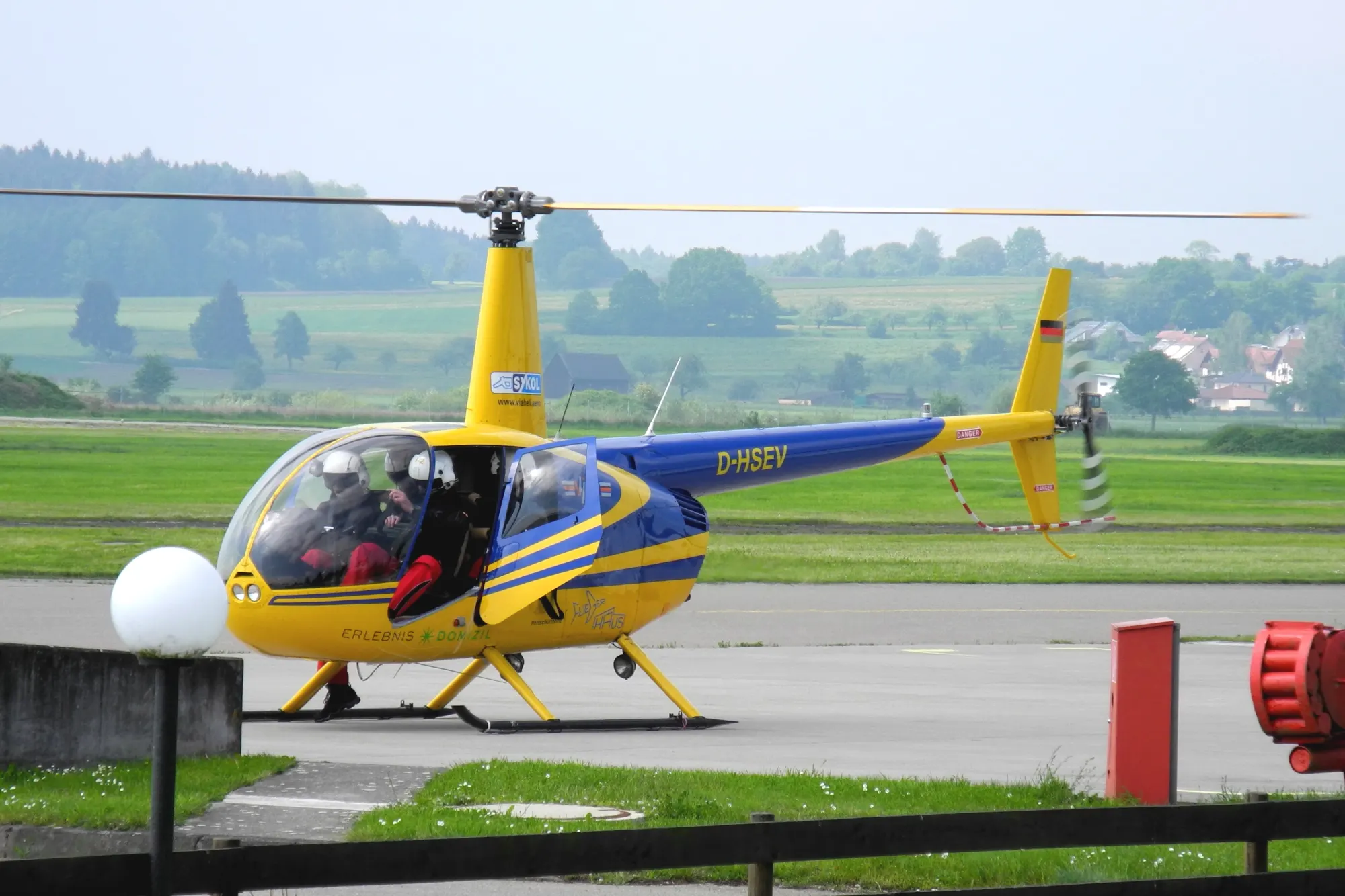 Gelber Robinson-Hubschrauber vor dem Start am Flugplatz