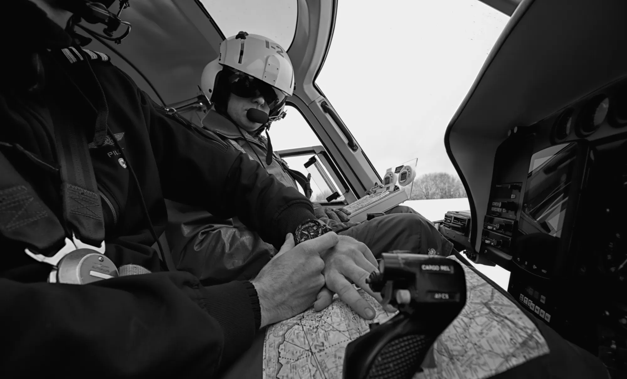 Pilot mit Helm im Cockpit, schwarz-weiß