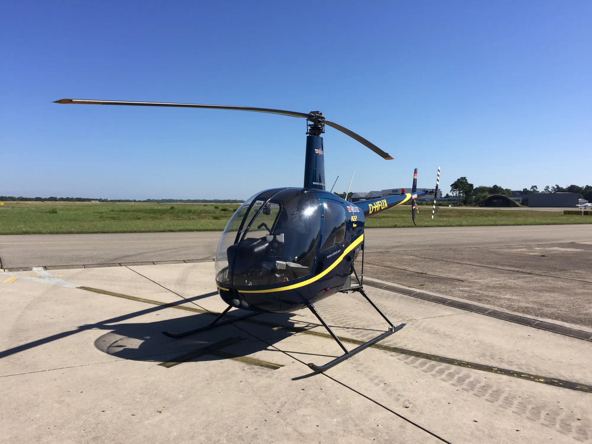 Robinson-Hubschrauber auf dem Vorfeld vor blauem Himmel