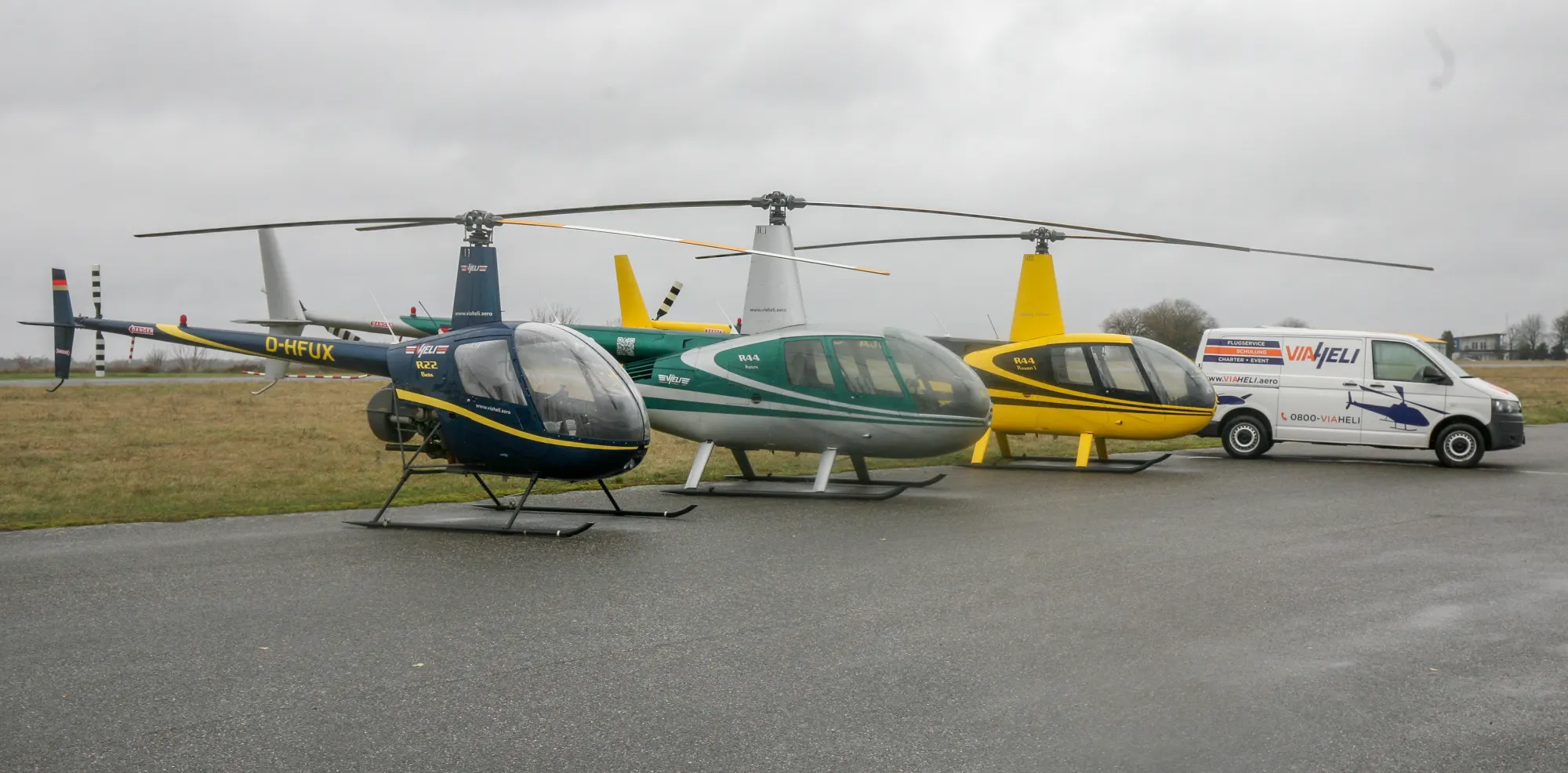 Hubschrauber verschiedener Muster nebeneinander auf dem Vorfeld