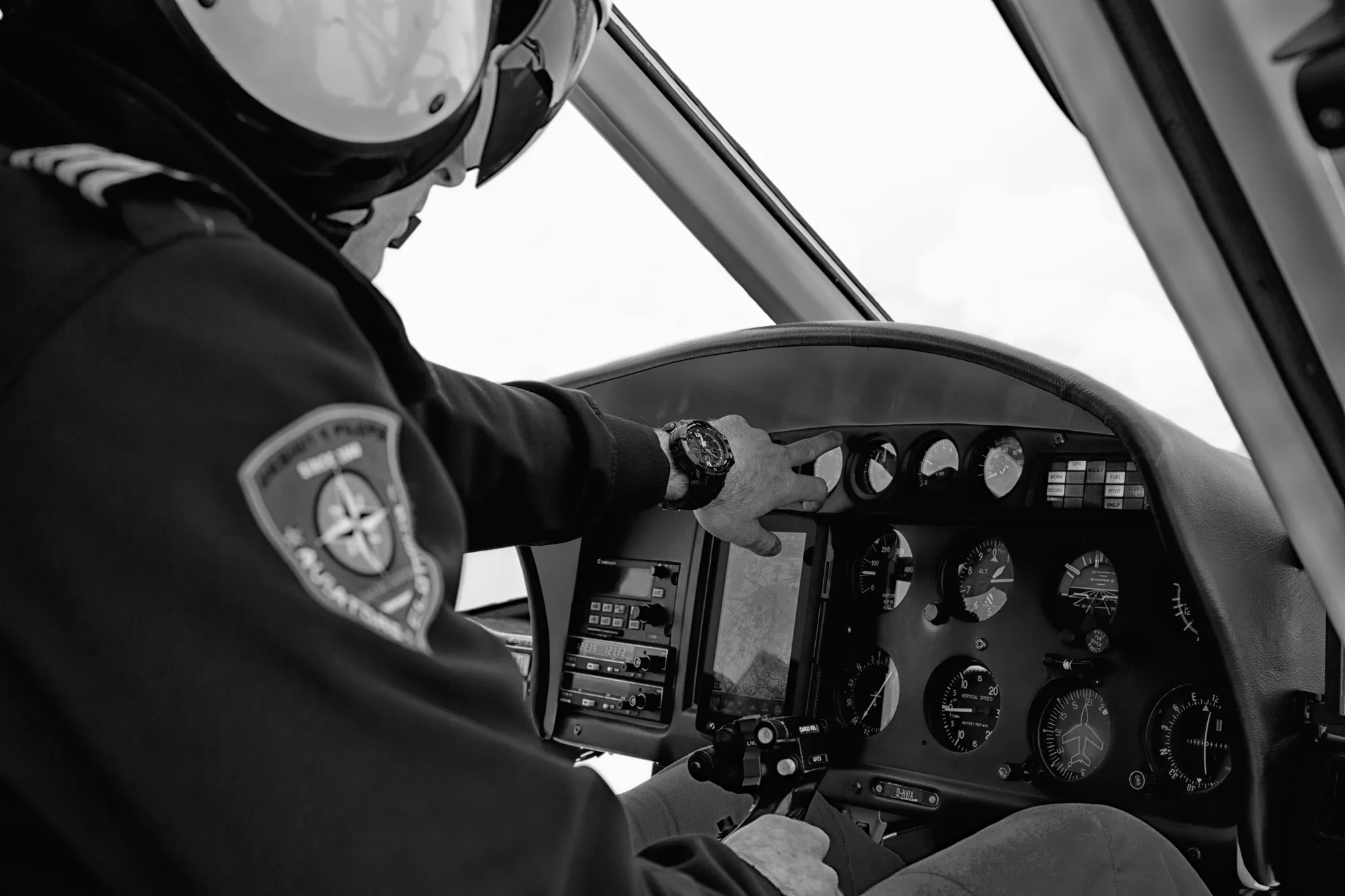 Pilot im Cockpit eines Hubschraubers, schwarz-weiß